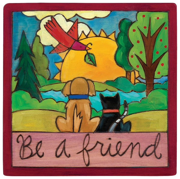 A cat and dog sitting in front of a sunny landscape on a wood wall plaque