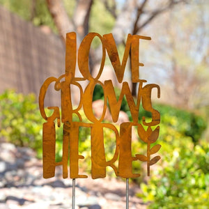 Love Lives Here garden stake in outdoor garden