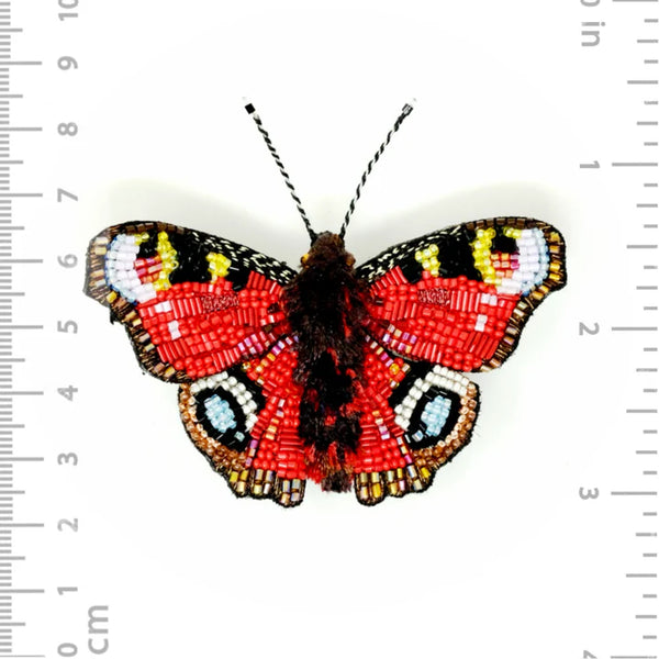Red beaded butterfly broach with inches for scale