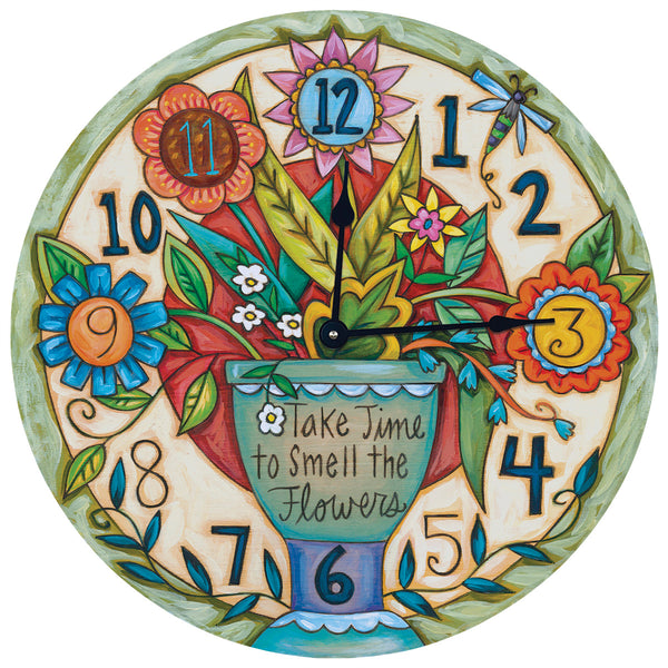 A colorful round clock with a floral design and the phrase 'Take time to smell the flowers' printed on it.