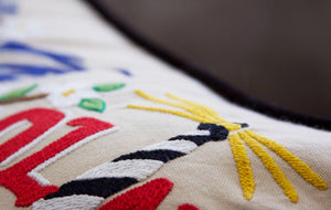 North Carolina Hand-Embroidered Pillow -  What a beautiful state! This original design celebrates the state of North Carolina—from Cape Fear to Asheville to Duck to Kitty Hawk, where man's first flight took place.