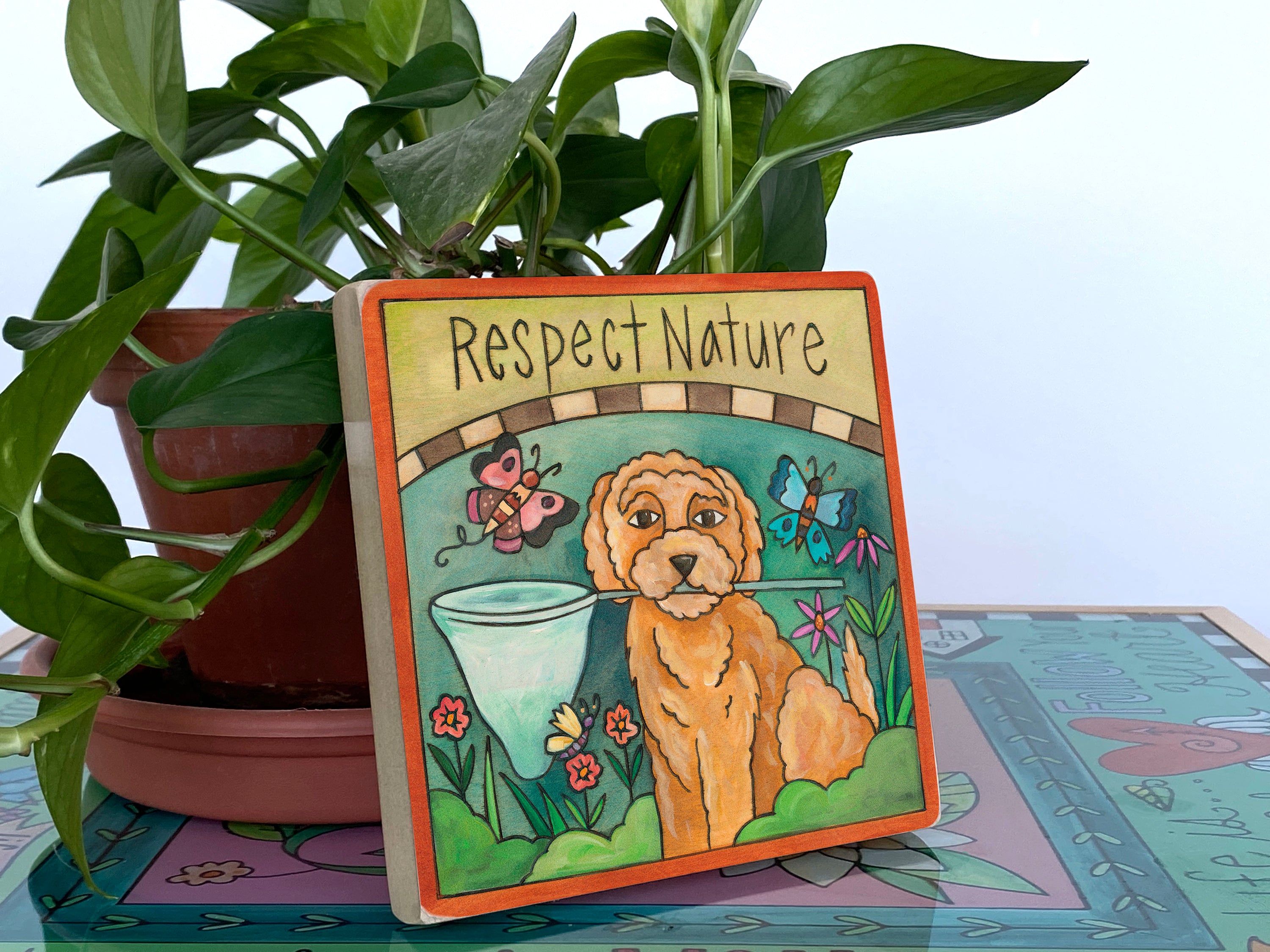 Decorative sign with a dog illustration and 'Respect Nature' text, placed among plants.
