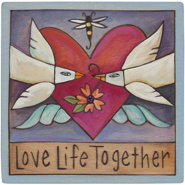 Decorative wall art with a heart, doves, and floral elements, featuring the text 'Love Life Together'.