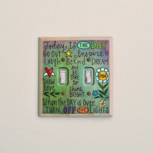 A cool-toned washed background with positive phrases on a double switch plate
