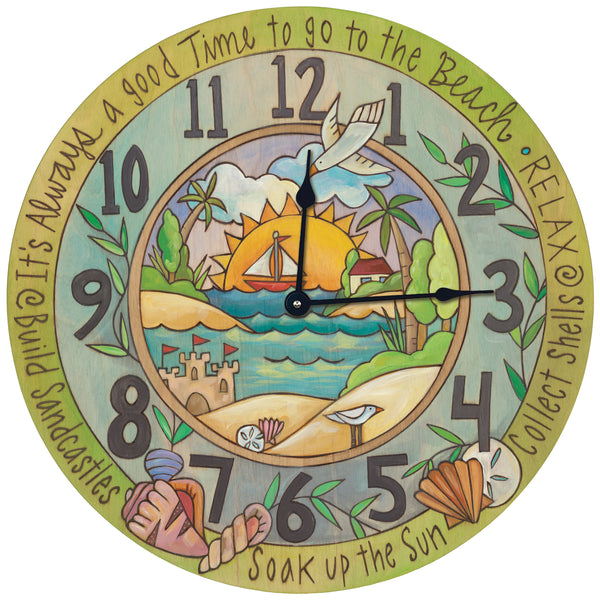 A round beach-themed wall clock with a colorful central illustration of a sunny beach scene, large dark gray numerals, and decorative text around the edge including 'It's Always a good Time to go to the Beach', 'RELAX', and 'Soak up the Sun'.