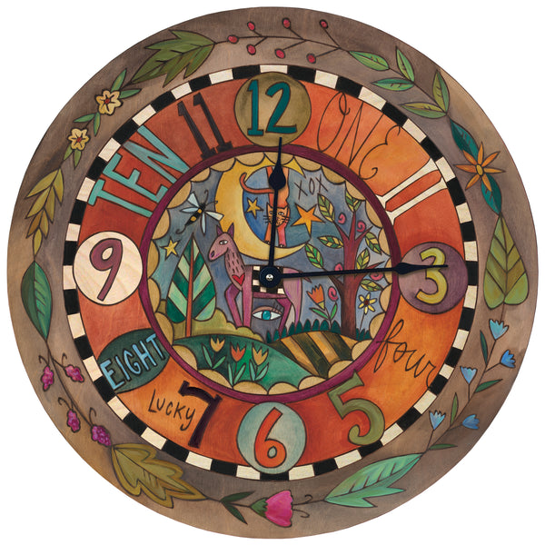 A round decorative wall clock featuring whimsical numbers, floral elements, and a central whimsical scene with a cat and moon on a warm orange and brown background.