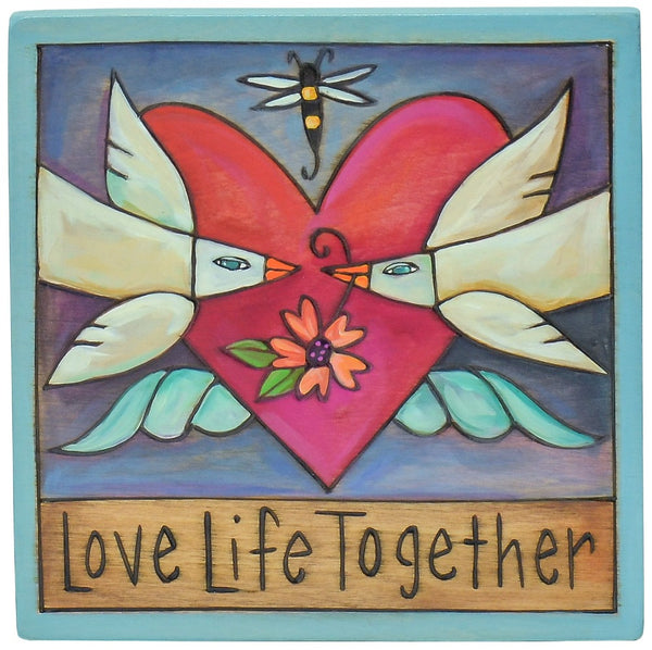 Two love birds and a heart with wings on a wood plaque