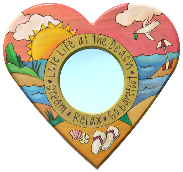 Heart-shaped mirror with beach-themed design and text on a white background