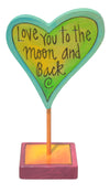 Heart-shaped sculpture with 'Love You to the Moon and Back' text on a stand