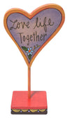 Heart-shaped sign with 'Love life Together' text on a stand with a white background