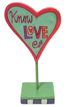 Decorative heart-shaped sign with 'Know Love' text on a white background