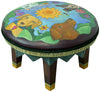 Colorful painted leather ottoman featuring four dogs heads with a nature motif, with dog themed text around the base.