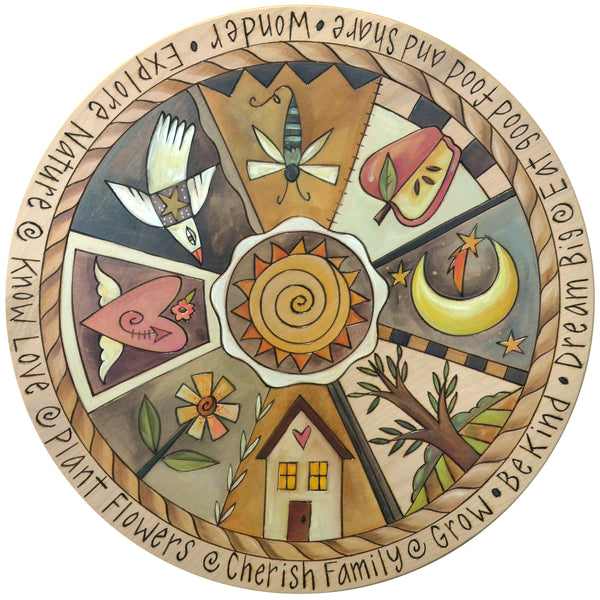 Birch lazy susan with various symbols including a house, sun, moon, and birds on a white background.