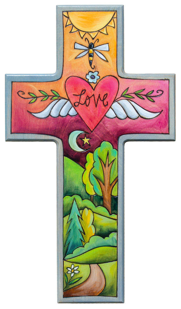 Decorative cross with nature-themed design, including a heart with 'LOVE', dragonfly, and landscape.