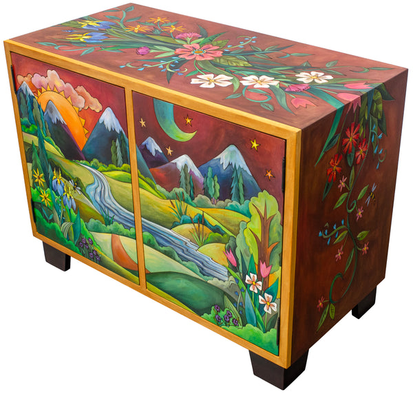 Decorative wooden media buffet with colorful mountain and floral design on a white background