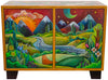 Wooden cabinet with painted scenes of mountains and landscapes on its doors.