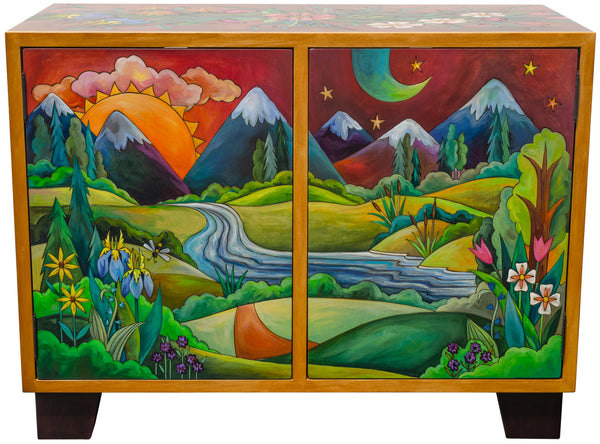 Wooden cabinet with painted scenes of mountains and landscapes on its doors.