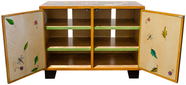 Wooden cabinet with open doors showing green shelves and decorative elements.