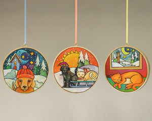 Dog and cat wood ornaments hanging in a line