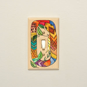 A colorful folk art snake printed on a wood light switch cover! 