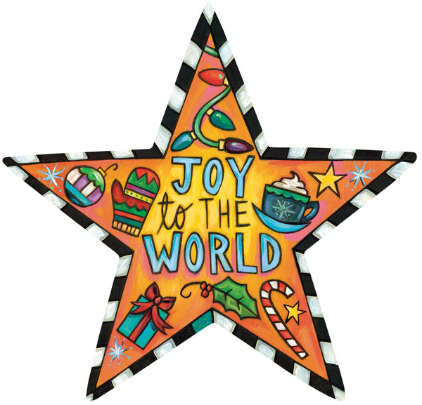 A five-pointed star-shaped Christmas tree topper featuring the words 'JOY to THE WORLD' in blue and yellow lettering. The Christmas tree topper is decorated with colorful holiday illustrations including a mug of hot cocoa with whipped cream, a wrapped gift, a candy cane, holly, a striped ornament, and a striped border, set against a plain white background.
