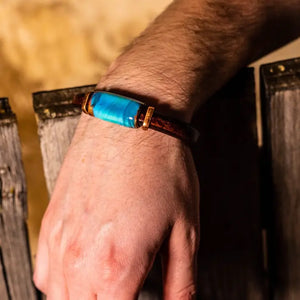 Cuff bracelet with turquoise colored bead on man's wrist