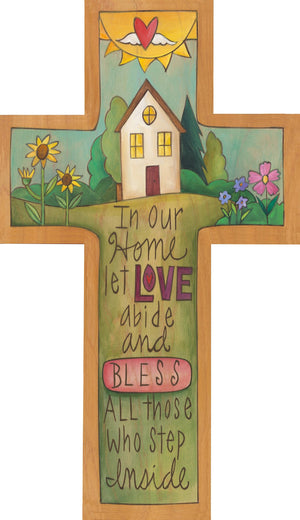 "All Are Welcome" Cross Plaque – "In our home let love abide" cross with a blessed home in a green landscape scene