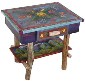 Nightstand with Open Shelf –  Eclectic folk art nightstand with birch legs and shelf designed with floral motifs and rolling mountain landscape