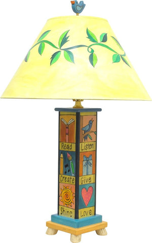 Fun and folky table lamp with vine-wrapped shade, bird finial, and base with cute boxed icons and coordinating phrases, front view