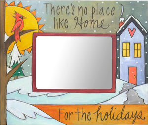 "There's no place like home for the holidays" frame with a house under a fresh blanket of snow