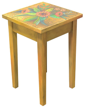 Beautiful natural wood toned end table with pink floral spray on top