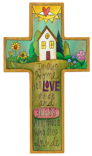 Cross Plaque – "In our home let love abide" cross with a blessed home in a green landscape scene