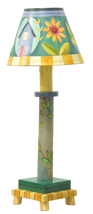 Log Candlestick Lamp – Beautiful blue lamp with a vine-wrapped base and shade with a home, flower, and landscape scene front view