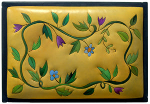 Ottoman – Classic, clean twisting vine ottoman design, both on the leather top and around the wood sides top view