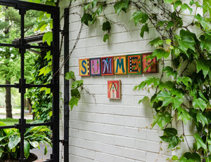 Sincerely, Sticks alphabet plaques spelling out Summer on a patio
