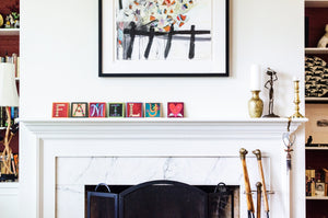 Example of Sincerely, Sticks alphabet letter plaques spelling out Family on a fireplace mantel