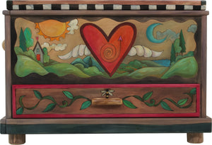Chest with Drawer – Beautiful heart with wings floating in a landscape with a twisting vine on its lid and patchwork motifs on the sides front view